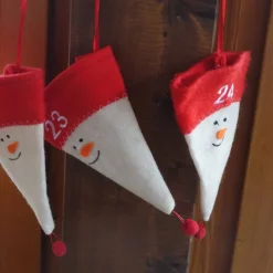 Adventskalender aus Filzmützen mit stilisiertem Schneemann-Gesicht