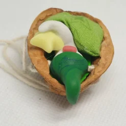 Baumschmuck Walnussschale Schaukelbettchen mit kleinem schlafend Wichtel mit Zipfelmütze und nachtleuchtendem Stern