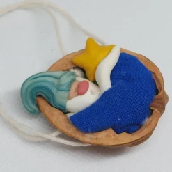 Baumschmuck Walnussschale Schaukelbettchen mit kleinem schlafend Wichtel mit nachtleuchtender Zipfelmütze und Stern