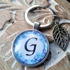 Buchstabe blauer Blumenkranz Anhänger bronze silberfarbe 25mm mit Blatt Schlüsselanhänger Cabochon