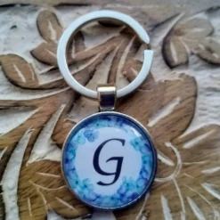Buchstabe blauer Blumenkranz Anhänger bronze silberfarbe 25mm mit Blatt Schlüsselanhänger Cabochon
