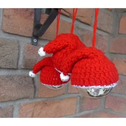 Drei Glasweihnachtsbaumkugel mit gehäkelten Nikolausmützen und Glöckchen