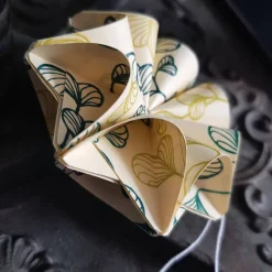 Dreidimensionale Geschenkanhänger aus Papier mit grünen Blättern – Origami Blüte in zwei Farben