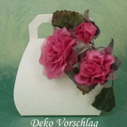 Duftiger Rosenzweig mit 3 Blüten, rosarot, als Deko auf einer Geschenkverpackung