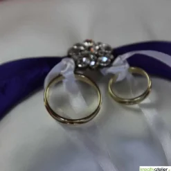 Elegantes Ringkissen aus weißem Satin mit lilanem Satinband und zarter weißer Schleife - Perfekte Hochzeitsdekoration