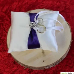 Elegantes Ringkissen aus weißem Satin mit lilanem Satinband und zarter weißer Schleife - Perfekte Hochzeitsdekoration