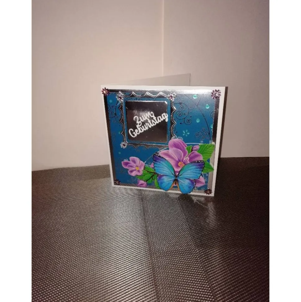 Geburtstagskarte für eine Frau in türkis, silber mit einem blauen Schmetterling