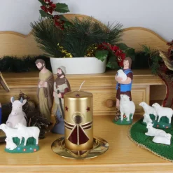 Goldene Weihnachtskerze mit weinrotem Engel