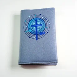 Gotteslob Filzhülle, mausgrau, bestickt mit einem Kreuz und 2 Fischen in einem strahlenden runden Ornament, blau