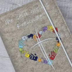 Gotteslobhülle Ihr seid meine Freunde, Kreuz mit Herz aus Händen; beige