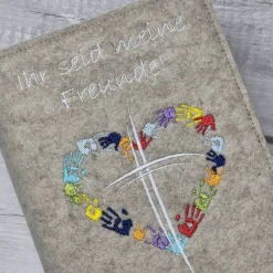Gotteslobhülle Ihr seid meine Freunde, Kreuz mit Herz aus Händen; beige