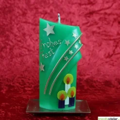 grüne Weihnachtskerze mit Kerzen und Sternen - ovale Formenkerze mit Bogenmotiv, verziert