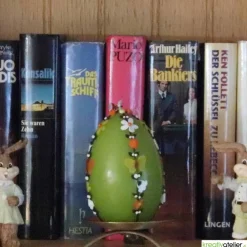 große Ostereikerze in grün mit doppelter, frühlingshafter Blumenranke verziert