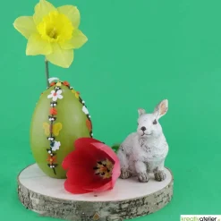 große Ostereikerze in grün mit doppelter, frühlingshafter Blumenranke verziert