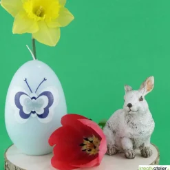 große Ostereikerze in hellblau mit Schmetterling in blau-weißem Verzierwachs
