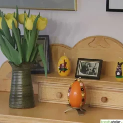 große Ostereikerze in orange mit doppelter, frühlingshafter Blumenranke verziert, Osterdeko, Ostergeschenk