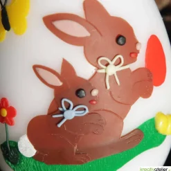 große Ostereikerze in weiß mit Hasenmutter, Hasenkind und bunten Ostereiern verziert, Osterdeko, Ostergeschenk