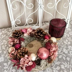 handgefertigtes Weihnachtsgesteck mit Trockenblumen und Windlicht Glas in rosa und Beerenfarben