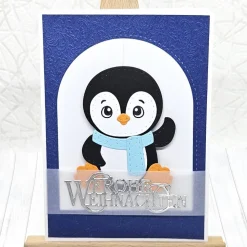 Handgemachte Weihnachtskarte A6 Pinguin mit blauem Schal | Unikat mit Umschlag & Dekoanhänger