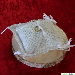 Liebevoll gefertigtes Ringkissen aus zartem Häkelstoff in reinweißer Farbe mit verspielten Herzchen und Satinschleifen