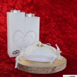 Liebevoll gefertigtes Ringkissen aus zartem Häkelstoff in reinweißer Farbe mit verspielten Herzchen und Satinschleifen