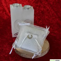 Liebevoll gefertigtes Ringkissen aus zartem Häkelstoff in reinweißer Farbe mit verspielten Herzchen und Satinschleifen