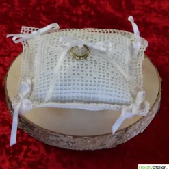 Liebevoll gefertigtes Ringkissen aus zartem Häkelstoff in reinweißer Farbe mit verspielten Herzchen und Satinschleifen