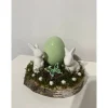 Osterdeko auf einer Baumscheibe Hasen grün