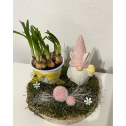 Osterdeko auf einer Baumscheibe mit Blumentopf und einem Wichtel