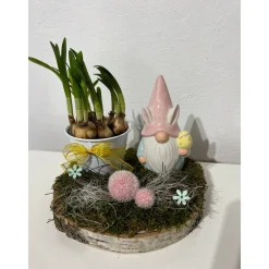 Osterdeko auf einer Baumscheibe mit Blumentopf und einem Wichtel