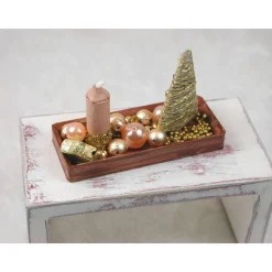 Rechteckige goldene  Platte mit beiger Kerze in weihnachtlicher  Dekoration