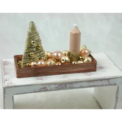 Rechteckige goldene  Platte mit beiger Kerze in weihnachtlicher  Dekoration