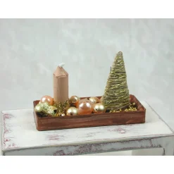 Rechteckige goldene  Platte mit beiger Kerze in weihnachtlicher  Dekoration