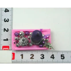 Rechteckige rosa Kunststoffplatte mit hochgebogenen Seiten mit violetter Kerze in weihnachtlicher  Dekoration