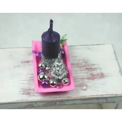 Rechteckige rosa Kunststoffplatte mit hochgebogenen Seiten mit violetter Kerze in weihnachtlicher  Dekoration