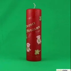 rote Silvesterkerze „Prosit Neujahr“ mit Glücksschweinchen und Kleeblättern