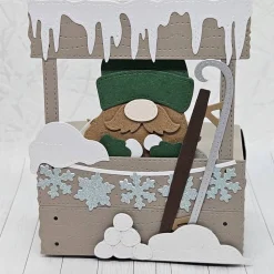 ​Rustikale Geschenkbox "Grünmützen-Wichtel mit Schlitten" | Handgemachte Verpackung mit abnehmbarem Wichtel-Anhänger