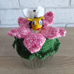 Schönes Glas mit Schraubverschluss, gehäkelter Blume und Biene