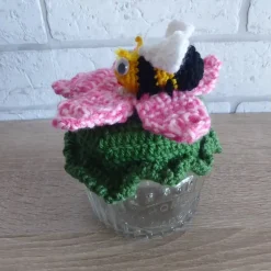 Schönes Glas mit Schraubverschluss, gehäkelter Blume und Biene