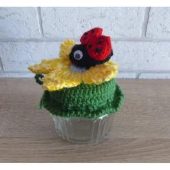 Schönes Glas mit Schraubverschluss, gehäkelter Blume und Marienkäfer