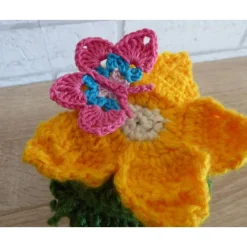 Schönes Glas mit Schraubverschluss, gehäkelter Blume (gelb) und Schmetterling