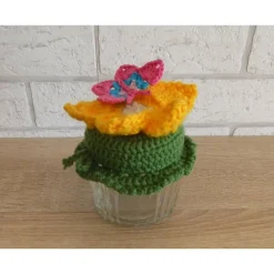 Schönes Glas mit Schraubverschluss, gehäkelter Blume (gelb) und Schmetterling
