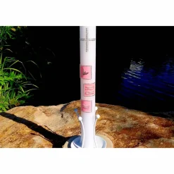 Weiße Taufkerze mit Kreuz und Taube, Fischen und Welle jeweils auf drei farbigen Kacheln, blau oder rosa