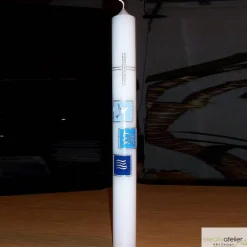 Weiße Taufkerze mit Kreuz und Taube, Fischen und Welle jeweils auf drei farbigen Kacheln, blau oder rosa