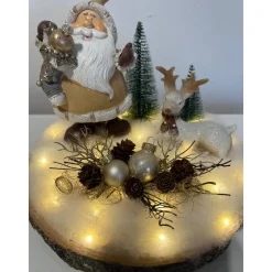 Weihnachtsdeko auf Baumscheibe mit Weihnachtsmann und Reh