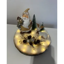 Weihnachtsdeko auf Baumscheibe mit Weihnachtsmann und Reh