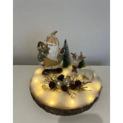 Weihnachtsdeko auf Baumscheibe mit Weihnachtsmann und Reh