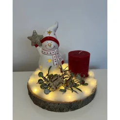 Weihnachtsdeko auf Baumscheibe mit Schneemann und Kerze