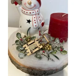 Weihnachtsdeko auf Baumscheibe mit Schneemann und Kerze