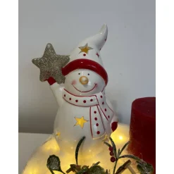 Weihnachtsdeko auf Baumscheibe mit Schneemann und Kerze